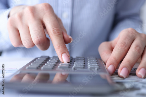 Female hands are counting on calculator at table closeup