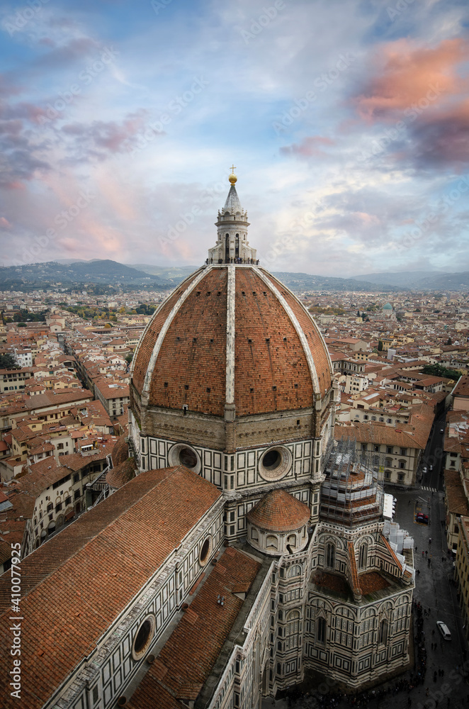 The Duomo in Florence, Italy, the Cathedral of Santa Maria del Fiore from the top with beautiful lights at cloudy day before sunset in Firenze