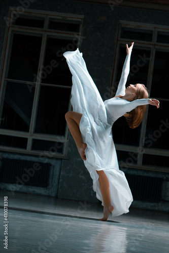 Fototapeta Naklejka Na Ścianę i Meble -  ballroom dancing in a white dress on a wooden floor, golan corner, beautiful dancer movement. contemporary