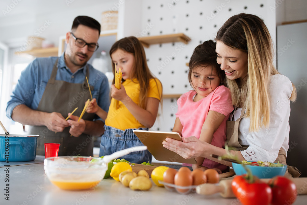 Overjoyed young family with kids having fun, cooking at home together Overjoyed young family with kids having fun, cooking at home together