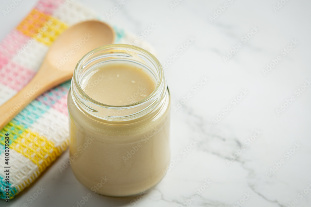tahini and sesame seeds on marble background tahini and sesame seeds on marble background