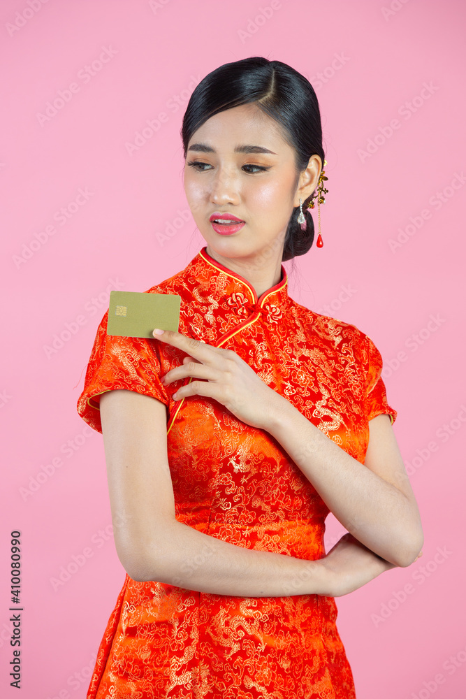 beautiful Asian woman happy smile and show credit card in chinese new year on pink background. beautiful Asian woman happy smile and show credit card in chinese new year on pink background.
