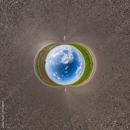 Inversion of blue little planet transformation of spherical panorama 360 degrees. Spherical abstract aerial view on road with awesome beautiful clouds. Curvature of space.