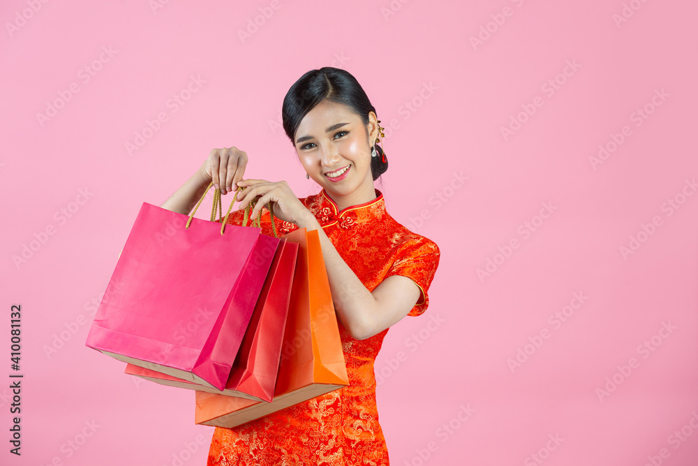 beautiful Asian woman happy smile and shopping in chinese new year on pink background. beautiful Asian woman happy smile and shopping in chinese new year on pink background.