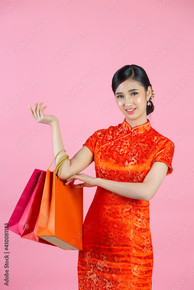 beautiful Asian woman happy smile and shopping in chinese new year on pink background. beautiful Asian woman happy smile and shopping in chinese new year on pink background.
