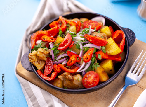 Fototapeta Naklejka Na Ścianę i Meble -  Pork ojakhuri with vegetables. Meat, potatoes, onions, herbs, peppers cooked and served in a skillet. A dish of Georgian cuisine. Meat food, lunch, dinner on the table.