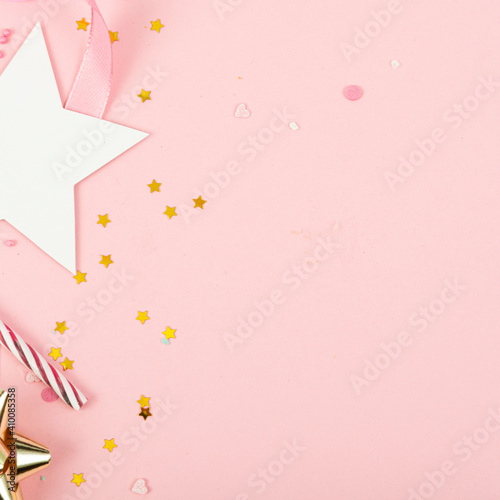 Party Holiday Background with ribbon, stars, birthday candles and confetti on pink background. Studio Photo