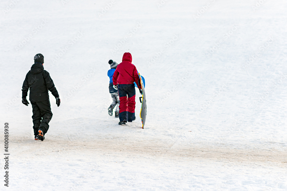 Some children skiers go up to hill mountain.Winter evening.