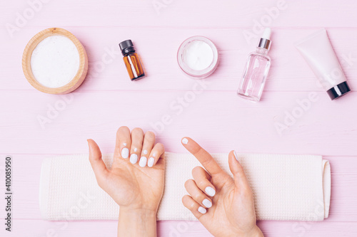 Self nail care at home, woman's hands apply cuticle cream