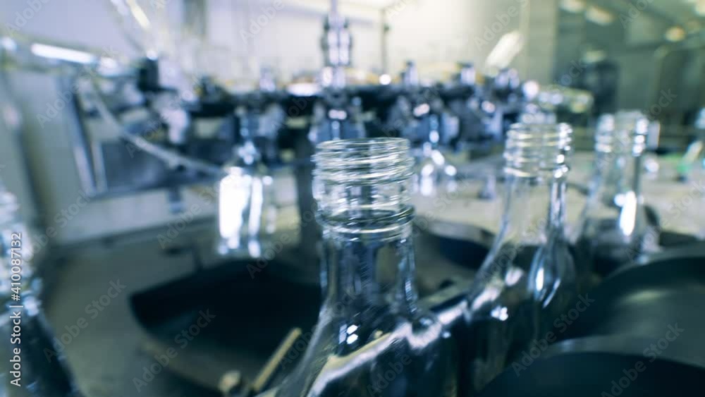 Empty bottles are being relocated by a factory conveyor Empty bottles are being relocated by a factory conveyor