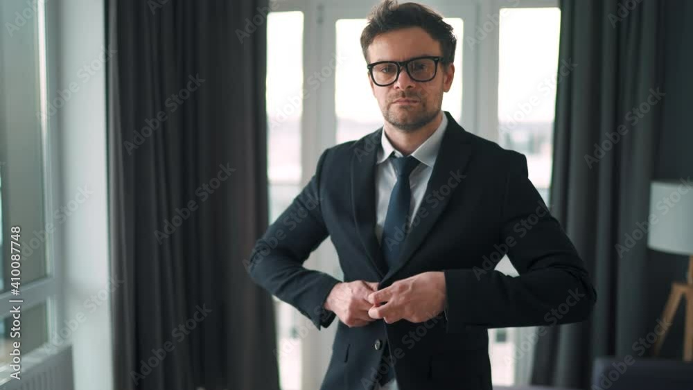 Portrait of a Caucasian man in glasses, a jacket and underwear in the interior of a modern home. Remote work during a pandemic