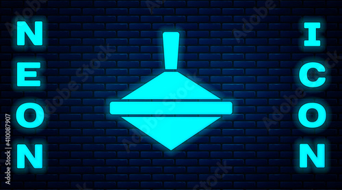 Glowing neon Whirligig toy icon isolated on brick wall background. Vector.