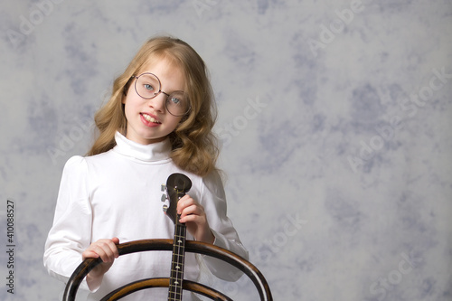 Cute little girl is playing dombra. photo