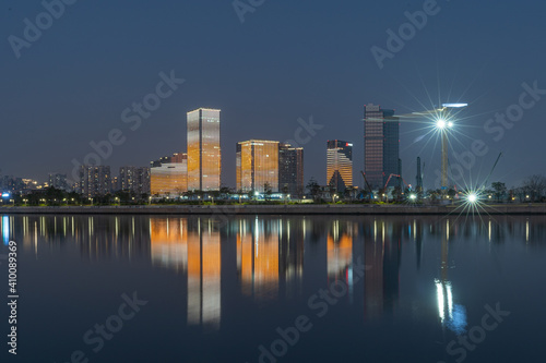 Modern cityscapes at night, modern city skyline in Xiamen Haicang district with water foreground, Xiamen, China