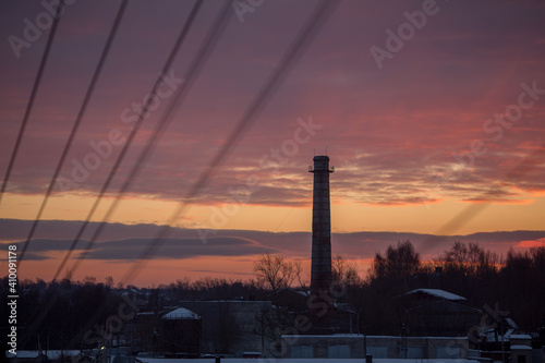 Chimney of the plant against the background of dawn. 