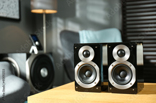 Modern audio speaker system on wooden table in living room