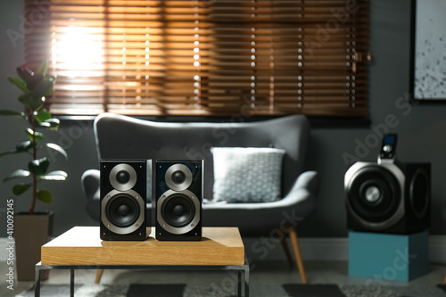 Modern audio speaker system on wooden table in living room. Interior design