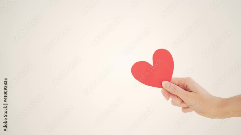 Red paper valentine in a woman's hand on a white background. Valentine's Day Red paper valentine in a woman's hand on a white background. Valentine's Day
