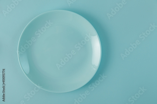 empty blue plate on same colored blue background. Top view