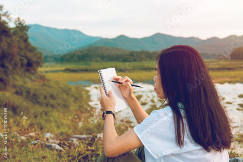 Asian young woman of student drawing pencil on plain air, landscape outdoors with sunset. Art education talented
