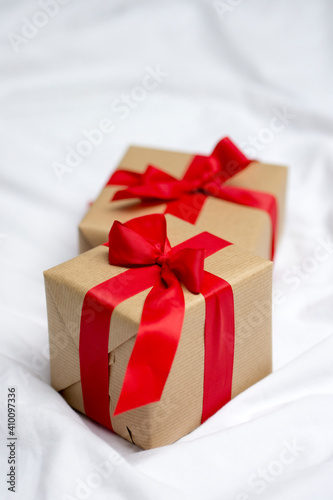 Red gift kraft box with ribbon. Valentine's Day gift in bed. Natural eco and bio gift. Sensual passion minimal gift in bed © Ruth