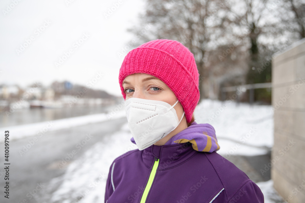 Obraz premium Young woman doing sport in winter outdoors in sportswear in ffp2 medical mask. Sport in Corona. Sportswoman. 