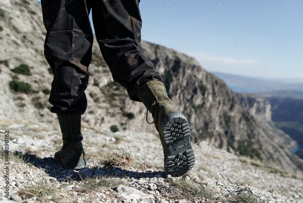 Man in Dark green lace-up boots in khaki pants Man in Dark green lace-up boots in khaki pants
