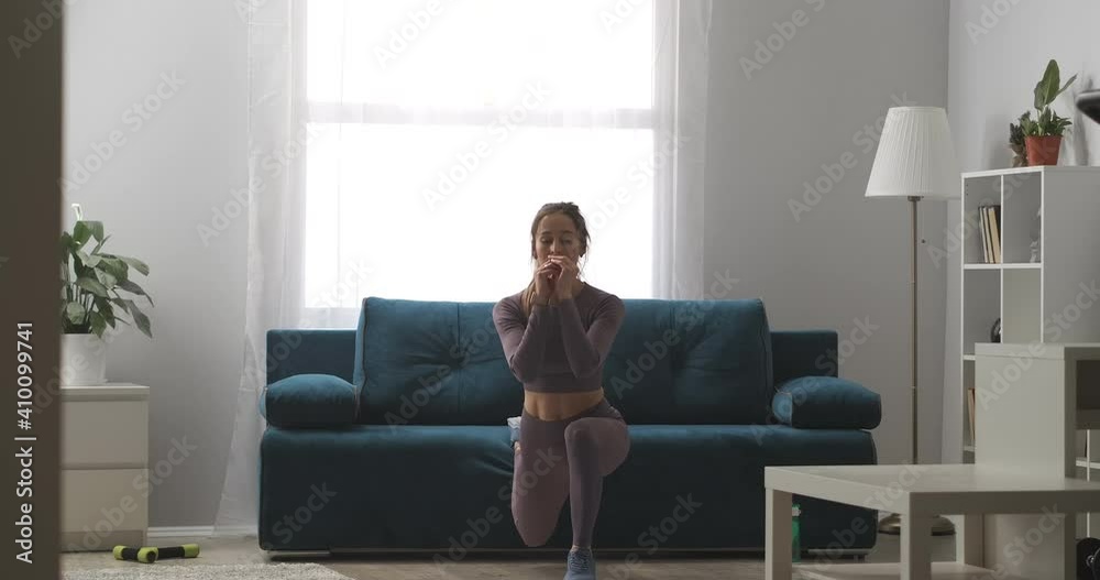 squatting for good body shape, woman is trainign alone in living room, home fitness for healthy lifestyle
