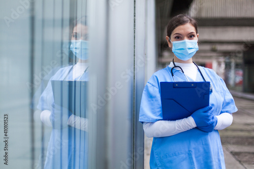 Young female NHS UK EMS doctor in front of healthcare ICU facility photo