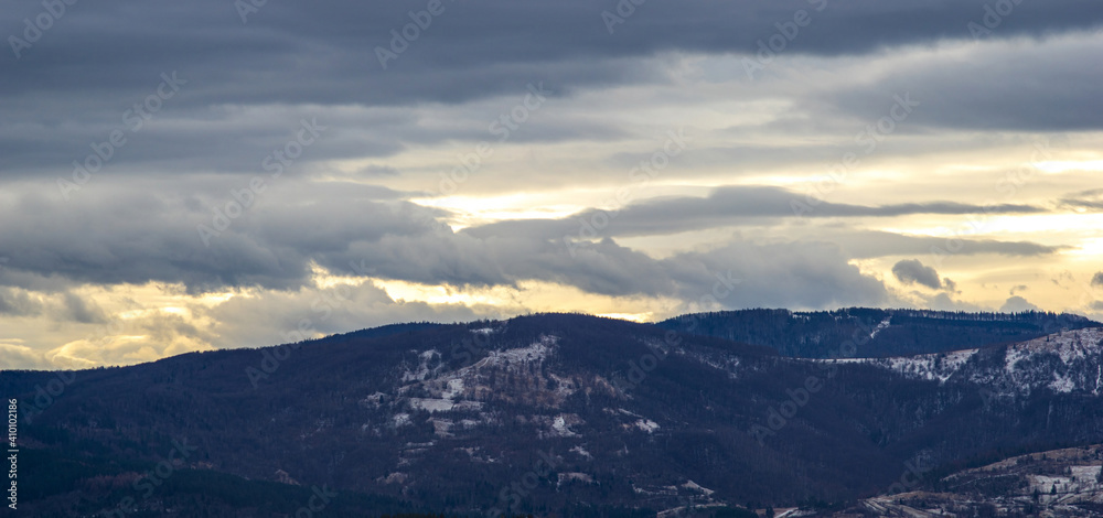 The Sun behind the clouds in winter in the mountains