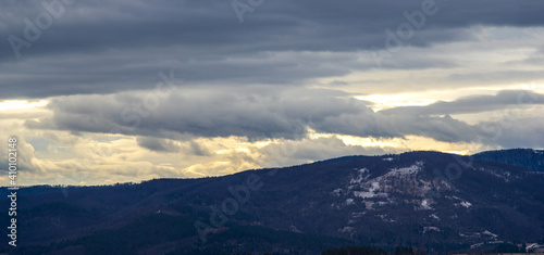 The Sun behind the clouds in winter in the mountains