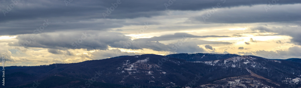 Obraz premium The Sun behind the clouds in winter in the mountains