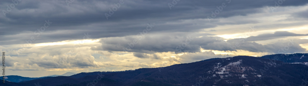 The Sun behind the clouds in winter in the mountains