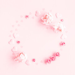 Valentine's Day background. Wreath made of pink flowers, hearts on pastel pink background. Valentines day concept. Flat lay, top view, copy space
