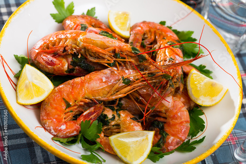 Delicious seafood dish, grilled shrimps served with parsley and lemon