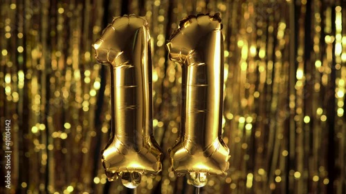 Gold foil number 11 eleven festive balloon on a yellow background. The concept of birthday, anniversary, date. photo