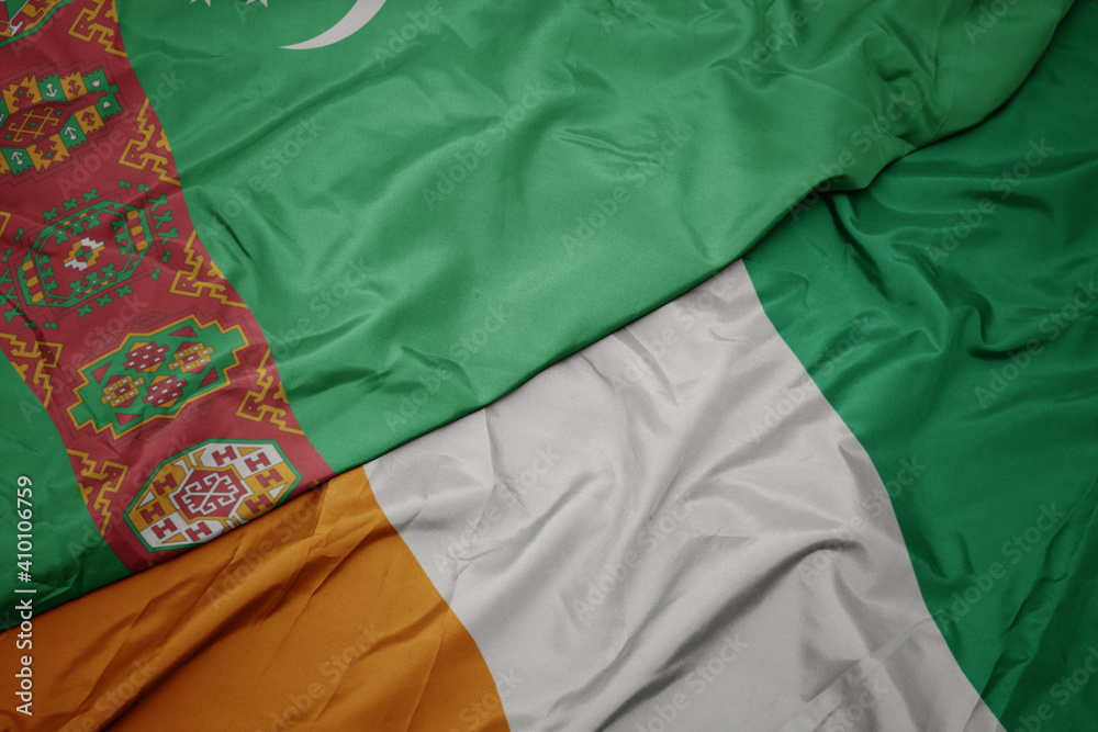 waving colorful flag of cote divoire and national flag of turkmenistan.