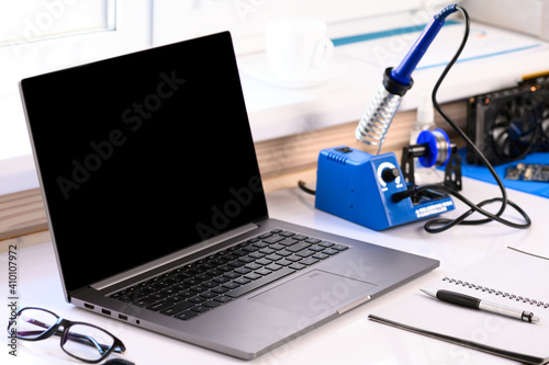 . Soldering courses. A computer and a soldering iron are on the table. Repair of gadgets. Online learning