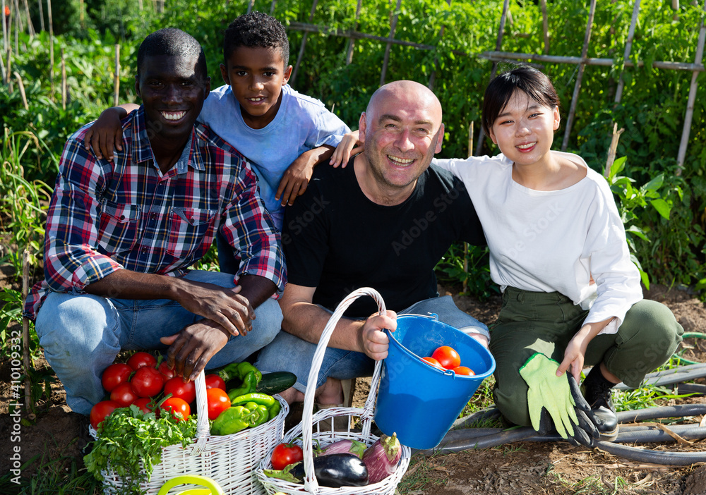 Obraz premium Portrait of friendly international family on farm field. High quality photo