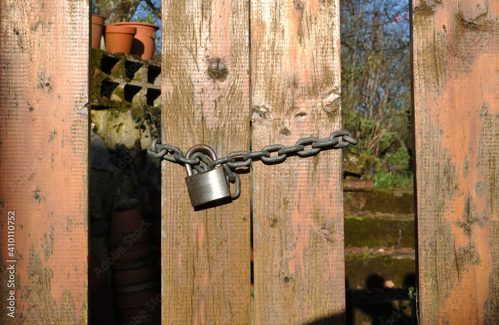Old Wooden Gate with Padlock and Chain in Close Up Old Wooden Gate with Padlock and Chain in Close Up