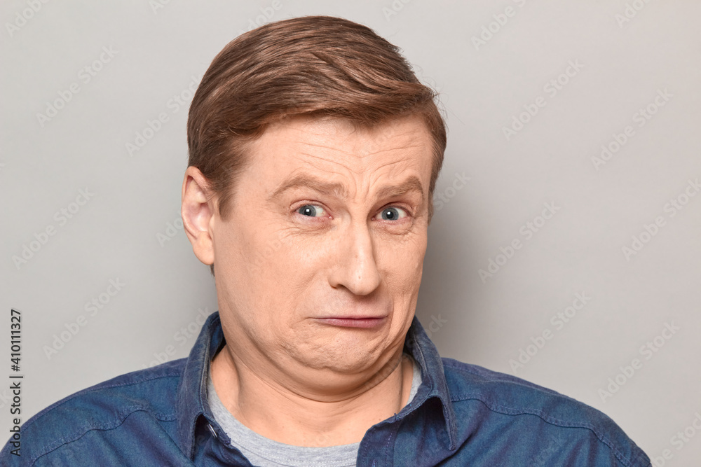 Portrait of unhappy fearful mature man grimacing from displeasure Portrait of unhappy fearful mature man grimacing from displeasure