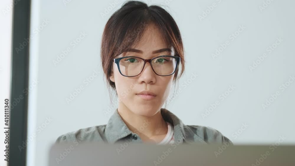 Beautiful asian woman is using laptop working in the office while drinking coffee Beautiful asian woman is using laptop working in the office while drinking coffee