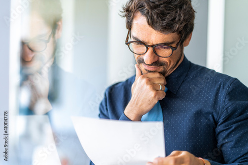 Billede på lærred Business man wearing glasses  holding paper document