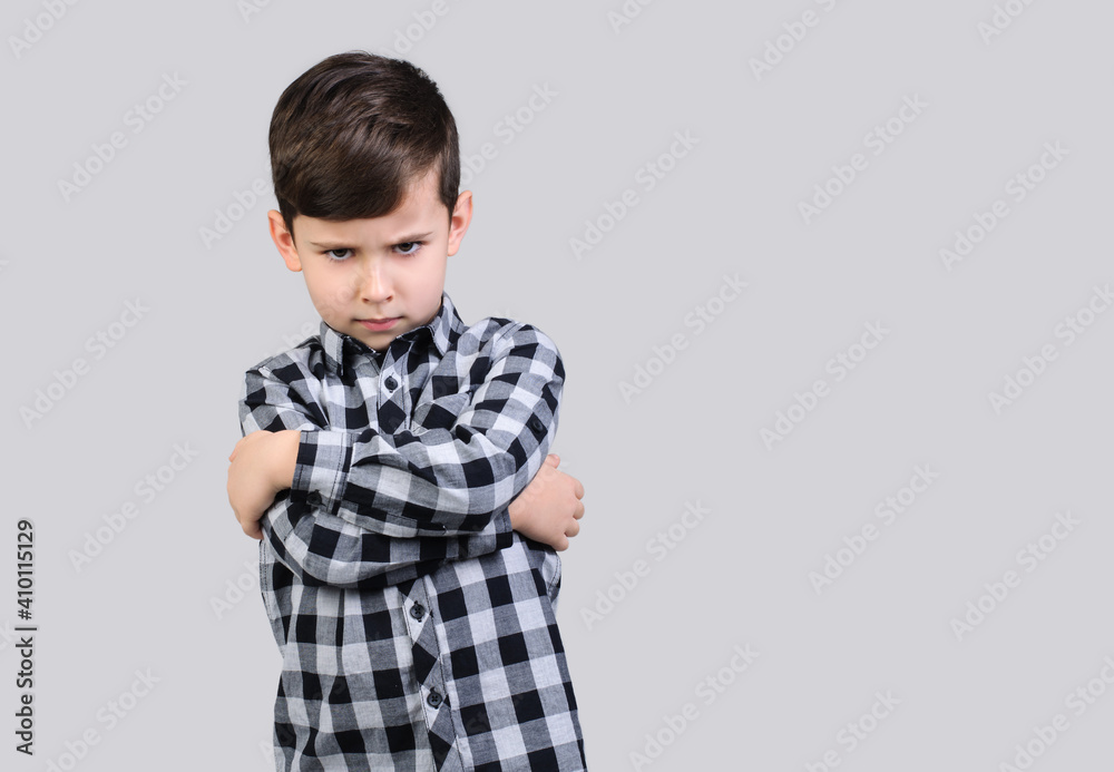 Boy in gray shirt is angry on studio gray isolated background, Unhappy schoolboy. The boy is offended Boy in gray shirt is angry on studio gray isolated background, Unhappy schoolboy. The boy is offended