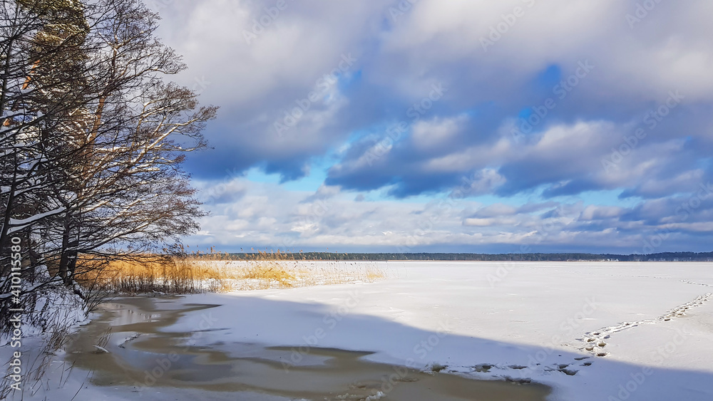 Panorama of a snowy lake with footprints in the snow in Riga, Latvia