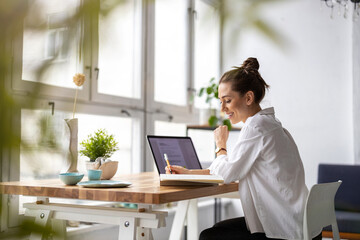 Creative young woman working on laptop in her studio
