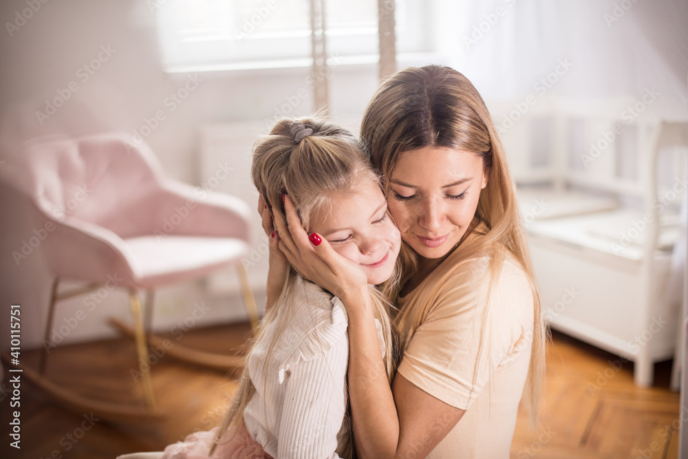 Portrait of mother and daughter in bedroom.