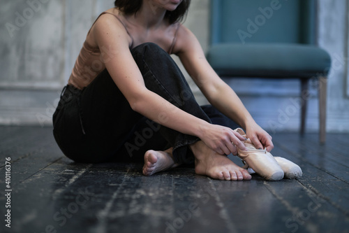 modern dancer in jeans puts on pointe shoes, classical and modern style concept in art.