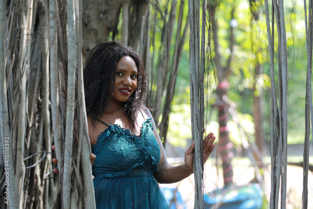Cheerful young woman standing by tree in the jungle. Cheerful young woman standing by tree in the jungle.