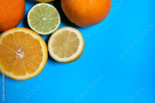 Whole and split oranges  limes and lemons with skin on a blue background. CITRUS CITRIC